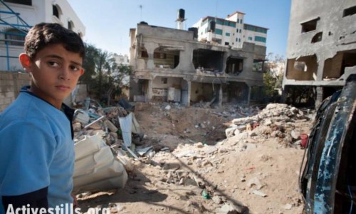 Pictured: A child stands amid the rubble of the Al Dalu family home, Gaza City, December 3, 2012. Ten members of the Al Dalu family were killed, as well as two neighbors, by an air strike on their three-story home on November 18, 2012, during the Israeli offensive known as “Operation Pillar of Cloud.” Four of those killed were children, and four were women. (Ryan Rodrick Beiler/Activestills.org)