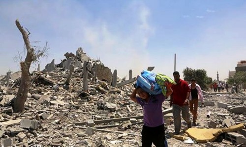 TODAY: Residents of Khuza'a go back to find their homes destroyed and retrieve bodies of loved ones from the ruins. In the background, smoke rises from Israeli shelling on the area, August 1st, 2014. By: Anne Paq/Activestills.org #GazaUnderAttack