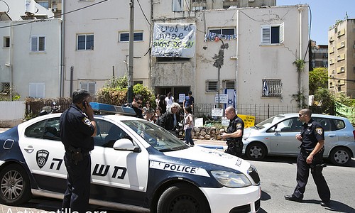 cc: flickr | A police car is seen in front of Itzik Menashe´s family, from the town of Givat Shmoel on may 26, 2013. Earlier this morning an eviction warrant was issued to Itzik and his wife lili. Activists and neighbors gathered in the early morning hours to resist the eviction and show solidarity with the family. Photo by: Yotam Ronen/Activestills.org