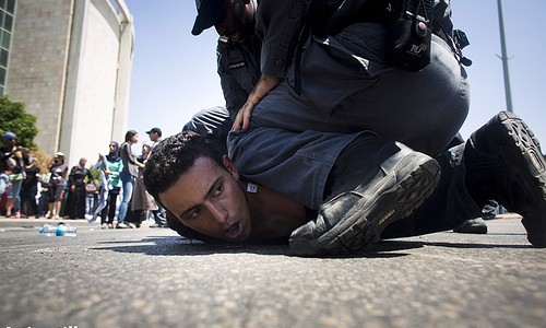 Israeli anti riot policemen arrest a protester as a few hundred Bedouin accompanied by activists from other parts of the country demonstrate against the Prawer Plan on July 15, 2013. Israeli police arrested 14 protesters during the demo. (Oren Ziv/Activestills.org)